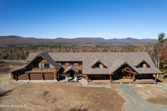 cabin featuring a garage, a mountain view, and log siding