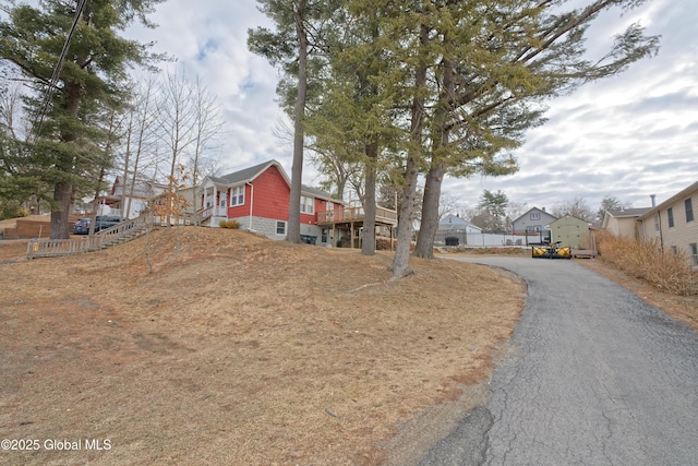 view of front of property featuring a residential view, fence, and stairway