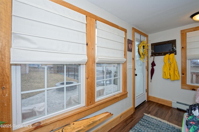 doorway with dark wood-style floors, baseboards, and baseboard heating