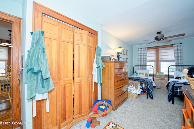 bedroom with ceiling fan, a closet, and carpet flooring