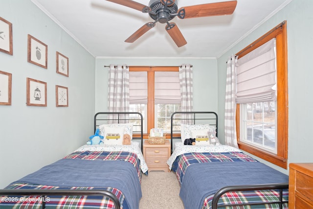 carpeted bedroom featuring a ceiling fan and crown molding