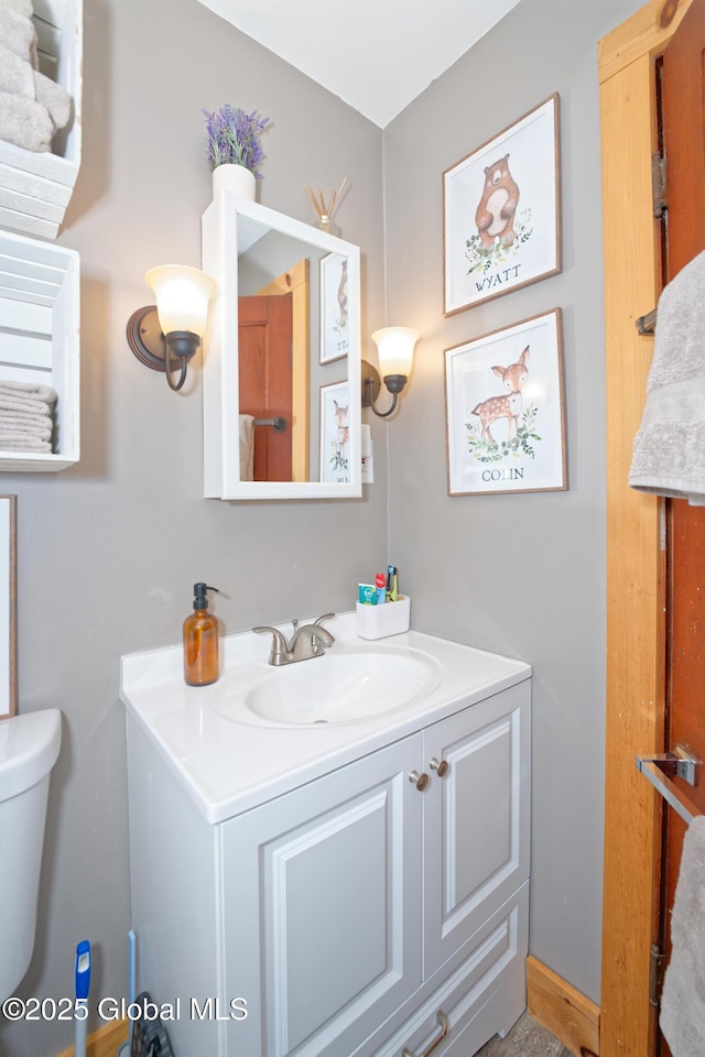 half bathroom featuring vanity and toilet