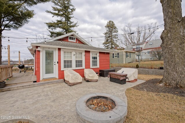 exterior space with an outdoor fire pit, fence, an outdoor structure, and a wooden deck