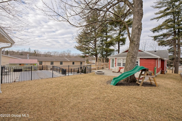 view of yard with a playground, fence, a fire pit, and a patio