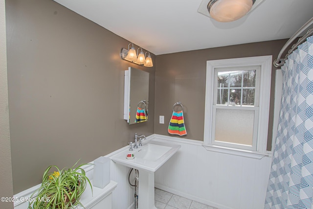 full bathroom with a wainscoted wall