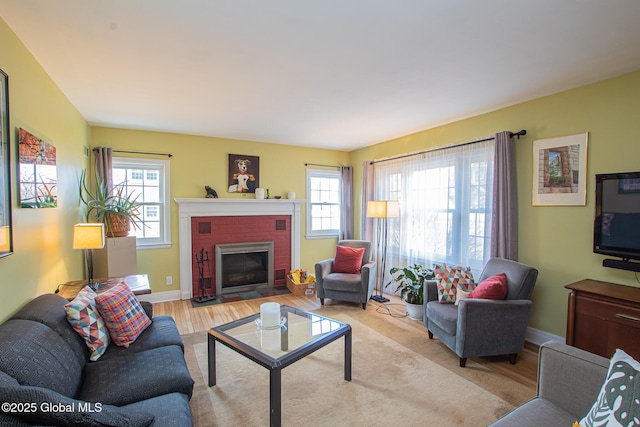 living room featuring wood finished floors, a fireplace, and baseboards