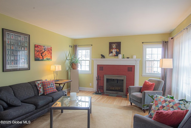 living area with wood finished floors, a fireplace, and baseboards