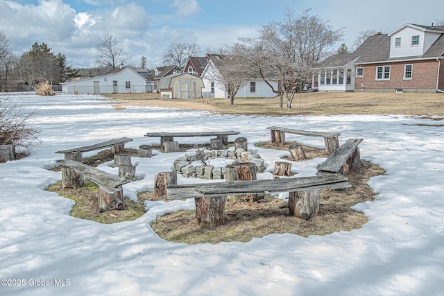 yard covered in snow with a residential view, an outbuilding, and a shed