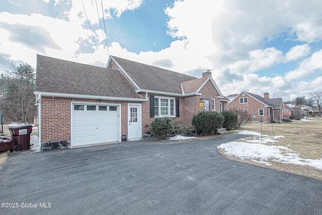 ranch-style home with aphalt driveway, a garage, brick siding, and a chimney