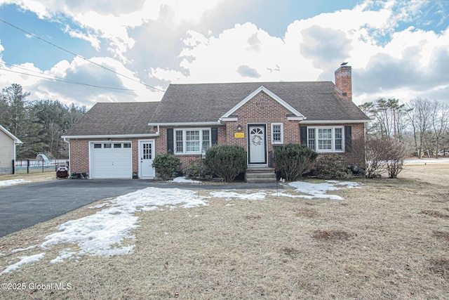 view of front of house featuring a garage, brick siding, driveway, and a chimney