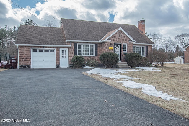 view of front facade featuring driveway, a shingled roof, a garage, brick siding, and a chimney