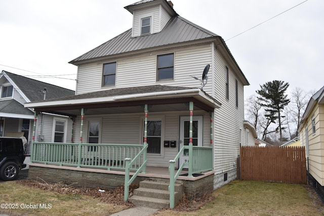 traditional style home featuring a porch, metal roof, and fence