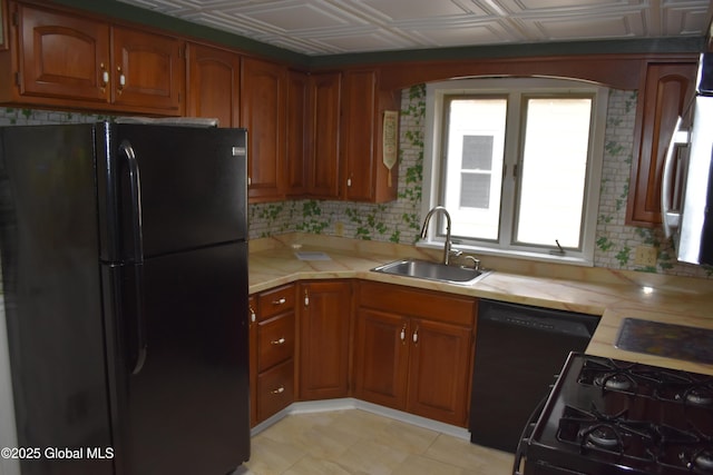 kitchen with black appliances, a sink, an ornate ceiling, brown cabinetry, and light countertops