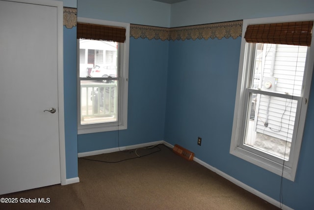 carpeted empty room featuring baseboards