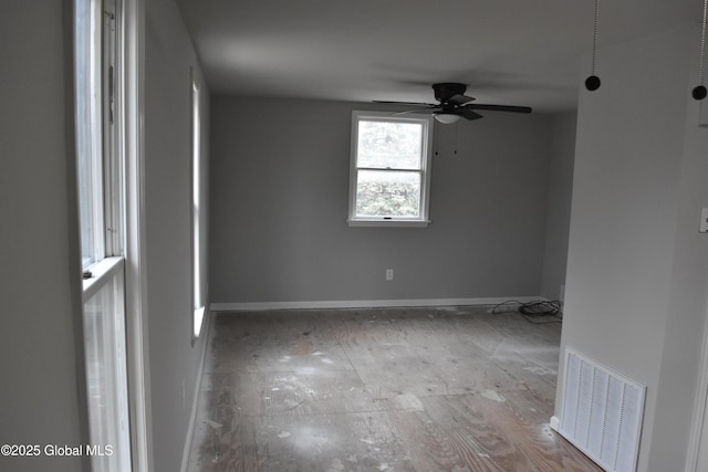 empty room with visible vents, baseboards, and ceiling fan