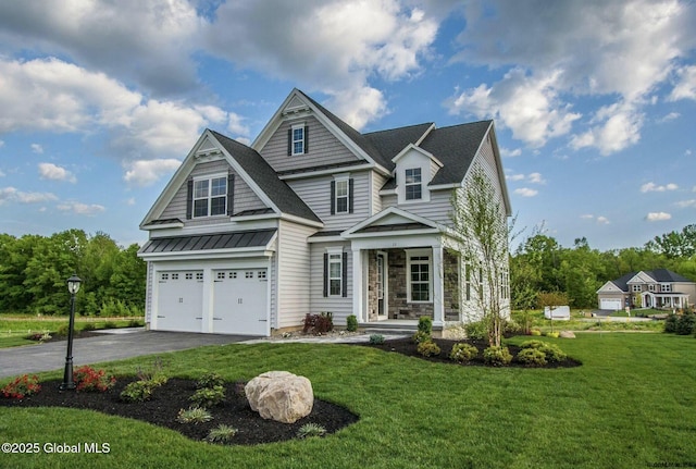 view of front of property with driveway, a standing seam roof, a front lawn, a garage, and metal roof