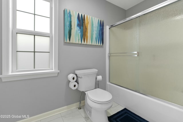 bathroom featuring toilet, baseboards, and enclosed tub / shower combo