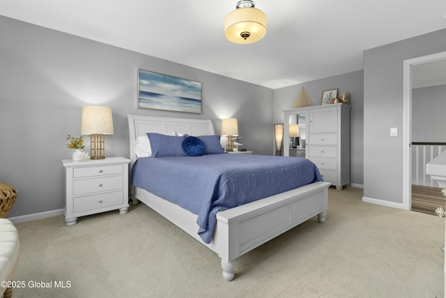 bedroom with light colored carpet and baseboards