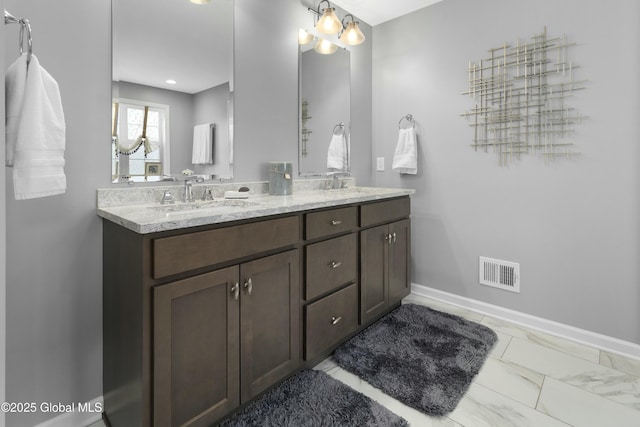 bathroom with a sink, visible vents, baseboards, and double vanity