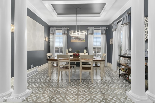 dining area with baseboards, a raised ceiling, and ornate columns