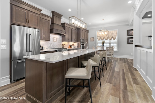 kitchen with dark wood finished floors, ornamental molding, custom range hood, high quality fridge, and tasteful backsplash