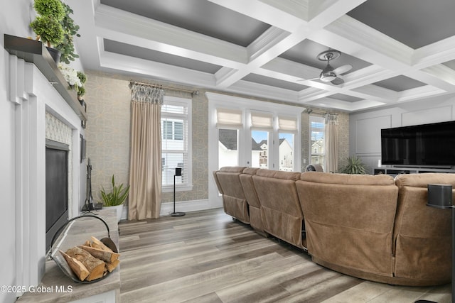 living room featuring a wealth of natural light, a fireplace, wallpapered walls, and light wood-type flooring