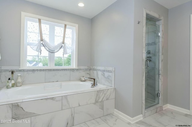 bathroom featuring a garden tub, a stall shower, marble finish floor, and baseboards