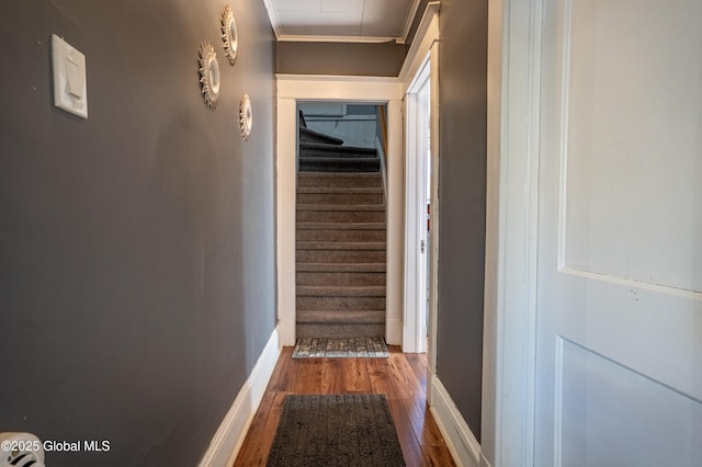 hallway with baseboards, stairs, ornamental molding, and wood finished floors