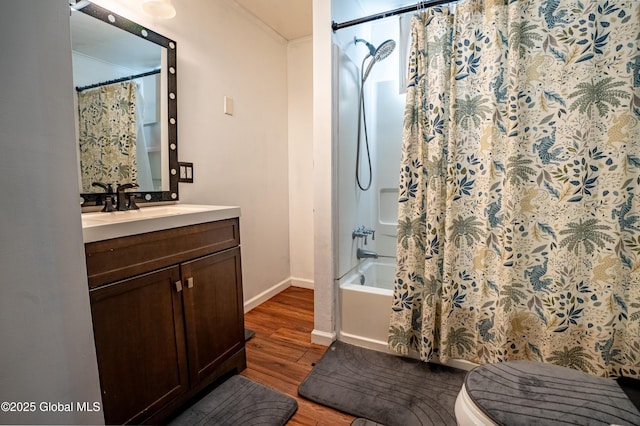 bathroom with baseboards, toilet, wood finished floors, shower / bath combo with shower curtain, and vanity