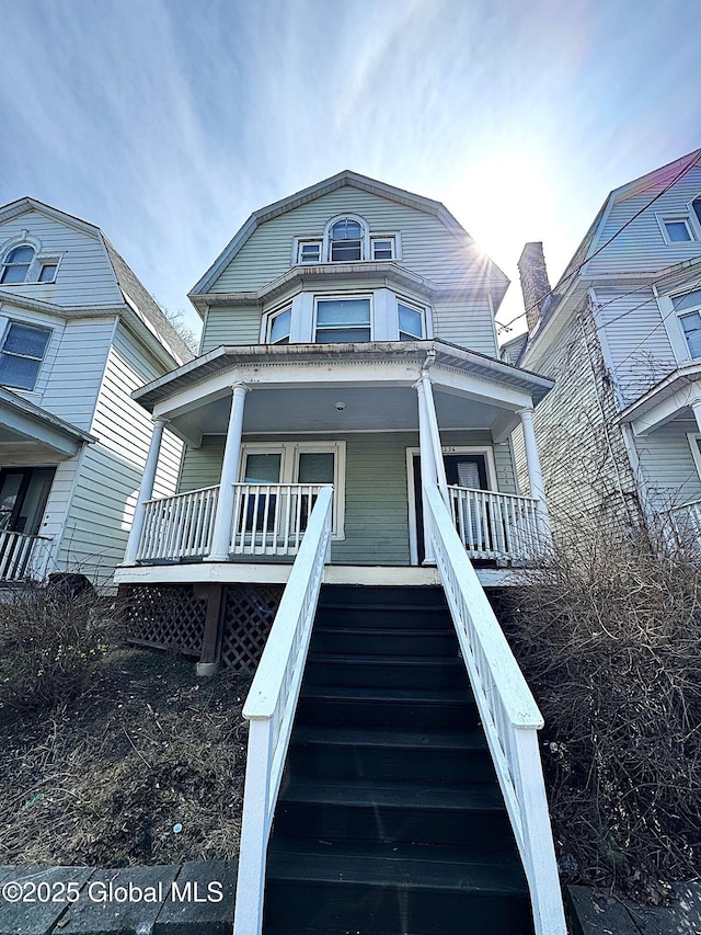 dutch colonial with covered porch and stairway