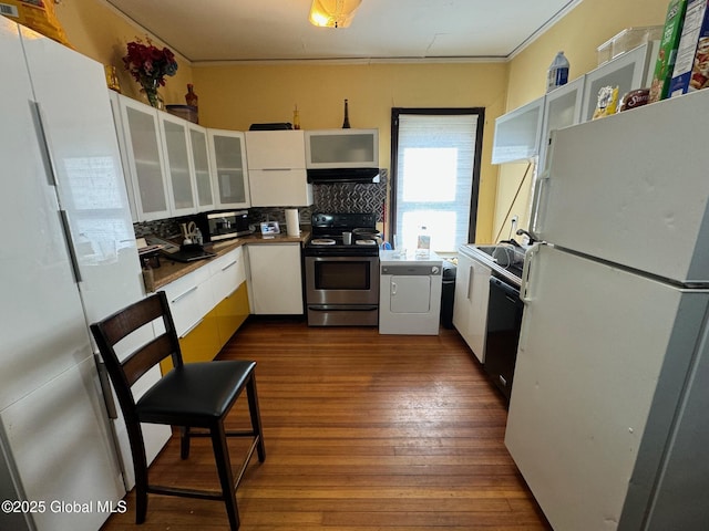 kitchen featuring white cabinets, decorative backsplash, dark wood-style floors, appliances with stainless steel finishes, and under cabinet range hood