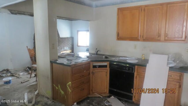 kitchen with a sink, black dishwasher, dark countertops, and a peninsula