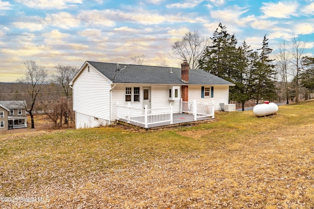 rear view of house featuring a yard, a shingled roof, crawl space, and a chimney