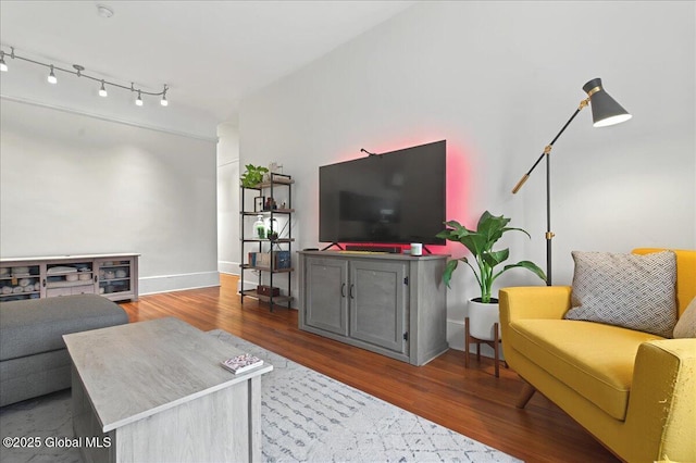 living area with baseboards and wood finished floors