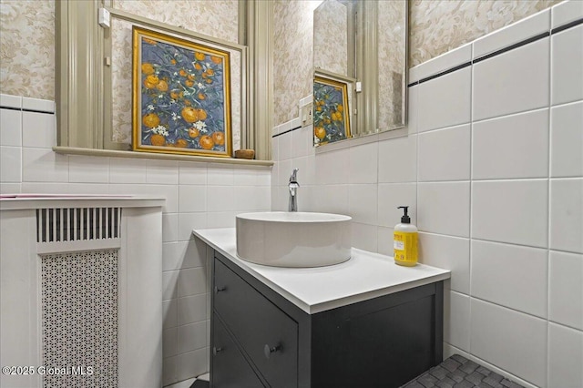 bathroom featuring wallpapered walls, tile walls, and vanity