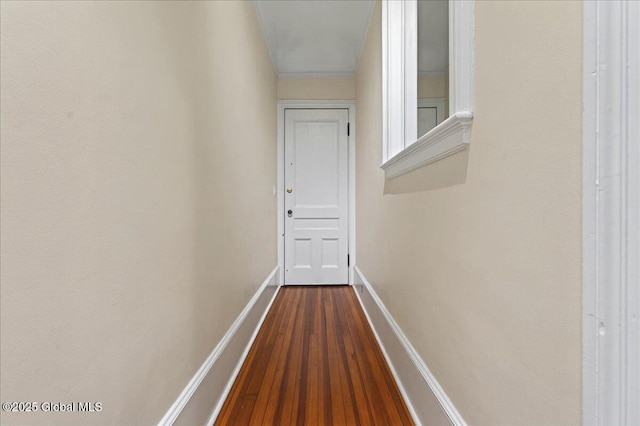 corridor with dark wood-style flooring and baseboards