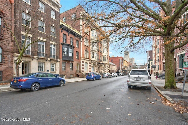 view of road with sidewalks, street lights, and curbs