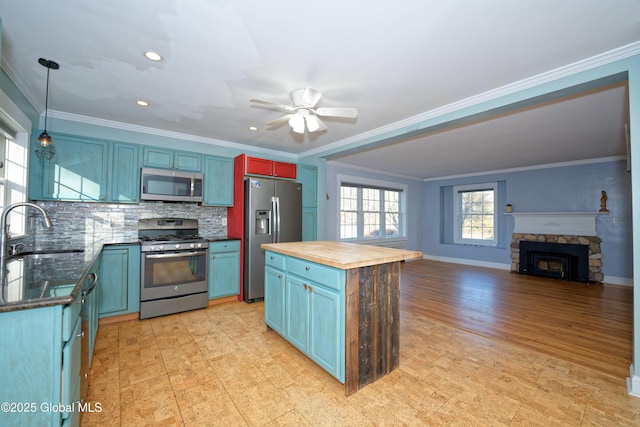 kitchen featuring a sink, appliances with stainless steel finishes, wood counters, crown molding, and backsplash