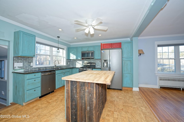 kitchen featuring butcher block countertops, tasteful backsplash, radiator heating unit, stainless steel appliances, and crown molding