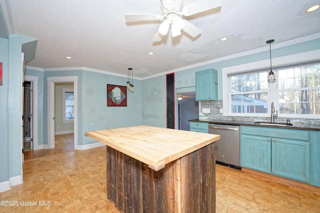 kitchen with blue cabinetry, a sink, dishwasher, a wealth of natural light, and butcher block counters