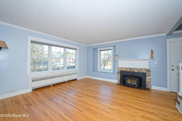 unfurnished living room featuring light wood-type flooring, baseboards, radiator heating unit, and crown molding