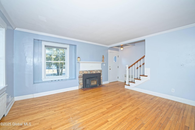 unfurnished living room featuring stairway, baseboards, ornamental molding, and light wood finished floors