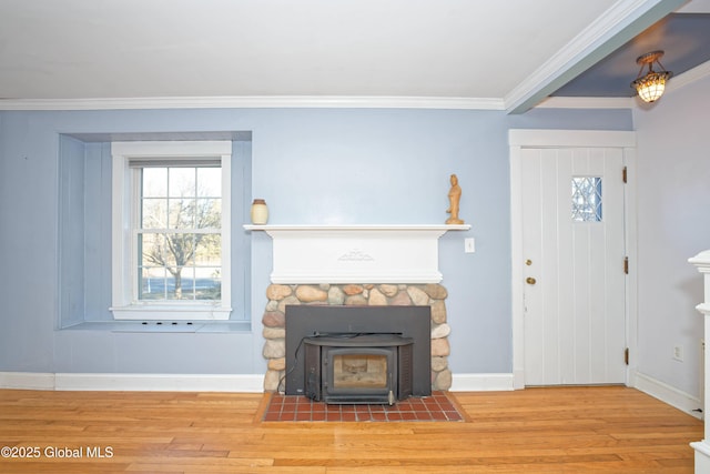 entrance foyer featuring crown molding, a wood stove, wood finished floors, and baseboards