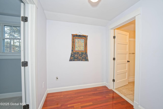 empty room featuring wood finished floors and baseboards