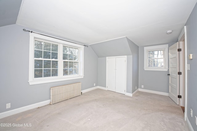 bonus room featuring carpet flooring, lofted ceiling, radiator heating unit, and baseboards