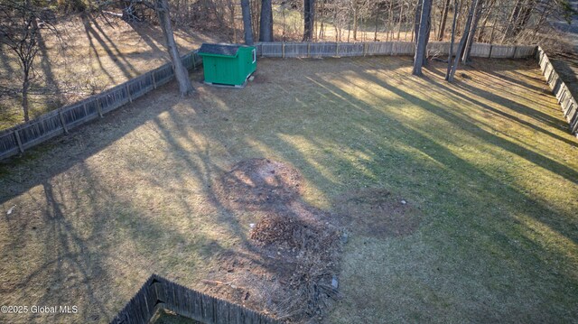 view of yard featuring a storage unit, an outdoor structure, and a fenced backyard