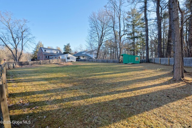 view of yard with a fenced backyard, a storage shed, and an outdoor structure