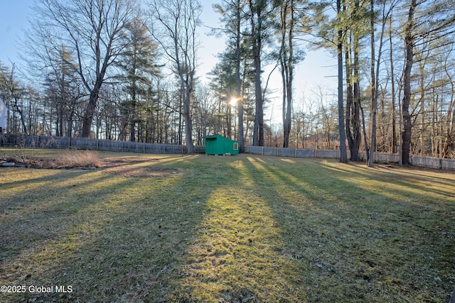 view of yard with a shed, an outdoor structure, and a fenced backyard