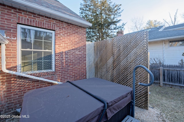 view of patio featuring fence and a hot tub