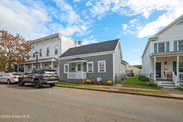 view of front of house with a chimney, fence, and roof with shingles